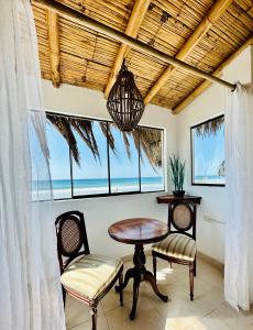 a dining room with a table and two chairs at Hotel Puerto Antiguo in Los Órganos