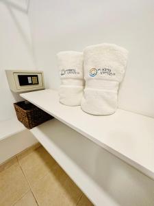 two towels sitting on a shelf in a bathroom at Hotel Puerto Antiguo in Los Órganos