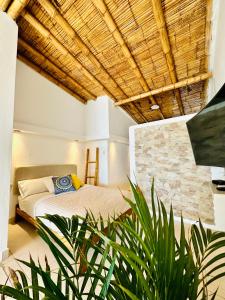 a bedroom with a bed and a stone wall at Hotel Puerto Antiguo in Los Órganos