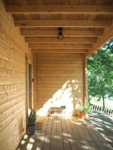 un porche cubierto de madera con un banco. en Sítio dos Carvalhos, en Covide