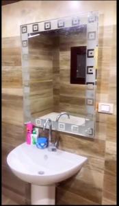 y baño con lavabo y espejo. en Mini VELLA ALJWHARA en Al Ḩammām