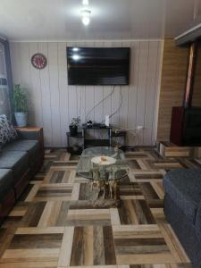 a living room with a couch and a glass table at Cabañas Roma in Valdivia