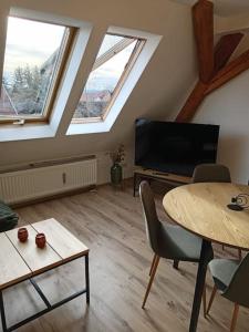 een woonkamer met een tv en een tafel met stoelen bij Ferienwohnung Allgäu 5 in Memmingen