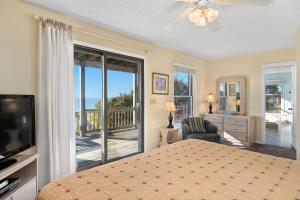 a bedroom with a bed and a television and a balcony at B20 Bay Meadow 20 in Nags Head