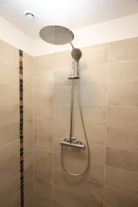 a shower with a shower head in a bathroom at Jaunlidumnieki in Mālpils