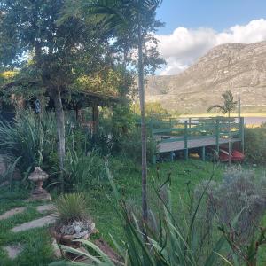 a bench in a garden with a mountain in the background at Casas e apartamentos da Praia, Lapinha na beira do lago in Santana do Riacho