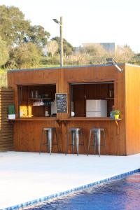 a bar on the side of a building with stools at Zambujal Suites in Sesimbra