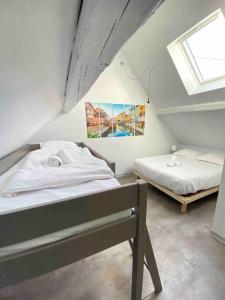 - une chambre mansardée avec 2 lits et une fenêtre dans l'établissement Le cocon du «Katzelberg» à 10mn de Colmar, à Katzenthal