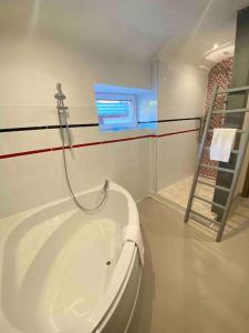 La salle de bains est pourvue d'une baignoire et de toilettes. dans l'établissement Le cocon du «Katzelberg» à 10mn de Colmar, à Katzenthal