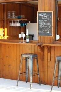 two chairs sitting at a bar with a bottle of wine at Zambujal Suites in Sesimbra
