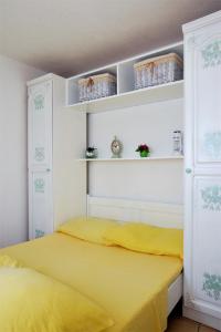 a bedroom with a yellow bed and white shelves at Apartments Ivica Mateljak in Brist