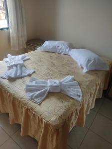 2 Betten mit weißer Kleidung darüber in der Unterkunft Apartamento Bela Vista in Rio das Ostras