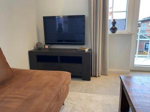 een woonkamer met een flatscreen-tv op een tafel bij De Bakkerij in Deurningen