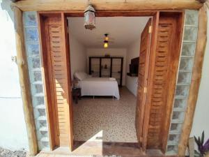 uma porta que leva a um quarto com uma cama em Suites na Vila em Maraú