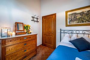 a bedroom with a blue bed and a dresser with a mirror at Casale il Fontanellino - country house near Florence in San Miniato