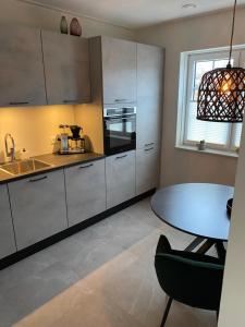 uma cozinha com uma mesa, um lavatório e uma mesa em De Bakkerij em Deurningen