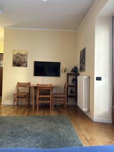 a living room with a table and a television on a wall at Apartment BelLenno in Lenno