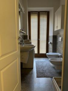 a bathroom with two sinks and a toilet in it at Apartment BelLenno in Lenno