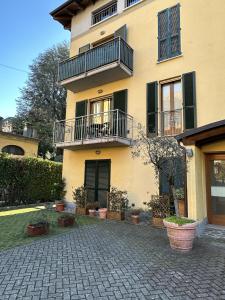 a large yellow building with balconies and potted plants at Apartment BelLenno in Lenno