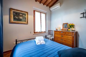 um quarto com uma cama azul e uma cómoda em Casale il Fontanellino - country house near Florence em San Miniato