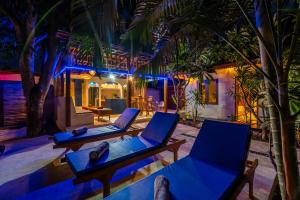 Paradise Luxury Villa في غيلي آير: كرسيين وطاولة في غرفة بها نخيل
