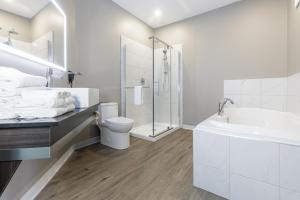 y baño con lavabo, aseo y ducha. en Quality Inn & Suites, en Victoriaville