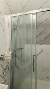 a shower with a glass door in a bathroom at COSY AND COMFY DOUBLE ROOM in London