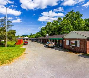 a parking lot with cars parked in front of a building at Travelers Inn Beaver 