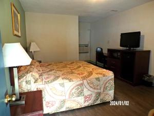 a hotel room with a bed and a flat screen tv at Travelers Inn Beaver 