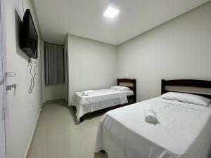 a room with two beds and a television in it at Hotel Brisas in Bom Jesus da Lapa