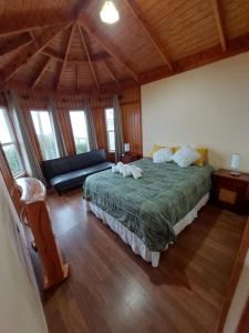 a bedroom with a large bed and a couch at Cabaña estilo Barco in Valdivia