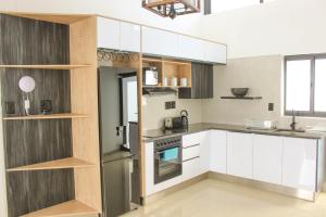 a kitchen with white cabinets and a stainless steel refrigerator at Deluxe Residence - Windhoek in Windhoek