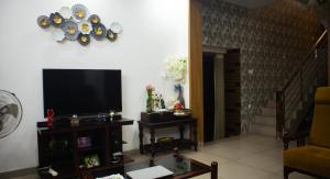 a living room with a flat screen tv on a wall at Urban Oasis Homestay: AC Bedrooms in Trichūr
