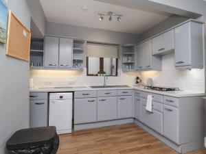 a kitchen with white cabinets and white appliances at 71 Nutter Road in Cleveleys