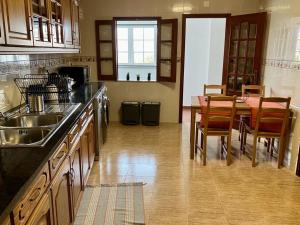 a kitchen with a table and chairs and a dining room at Alojamentos Vila Alpalhão in Alpalhão