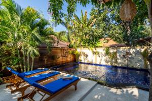 una piscina con sedie a sdraio blu e una piscina di Paradise Luxury Villa a Gili Air