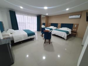 a hotel room with two beds and a tv at Alissthon in Santa Cruz de la Sierra