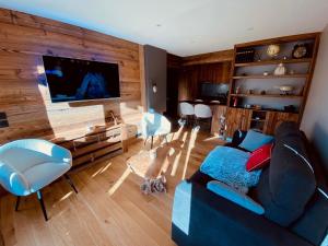 a living room with a blue couch and a flat screen tv at Appartement La Clusaz, 3 pièces, 6 personnes - FR-1-459-203 in La Clusaz