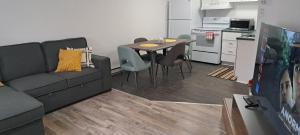 a living room with a couch and a table with chairs at Le Cent Onze in Gatineau +1 photo