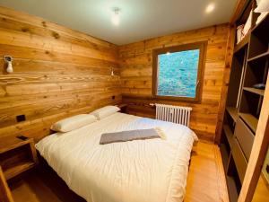 a bedroom with a bed in a wooden room at Appartement La Clusaz, 3 pièces, 6 personnes - FR-1-459-203 in La Clusaz