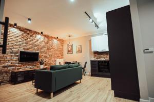 - un salon avec un canapé et un mur en briques dans l'établissement LOFT Luxury Apartment & Parking, à Leszno