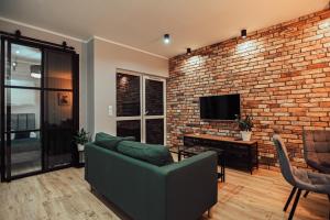 - un salon avec un canapé et un mur en briques dans l'établissement LOFT Luxury Apartment & Parking, à Leszno