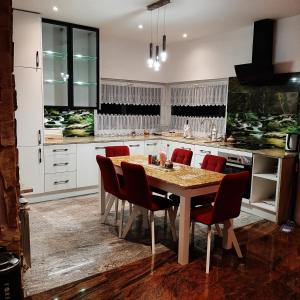 cocina con mesa de madera y sillas rojas en 3 kroki od sosny Domek w lasku Sitaniec en Zamość