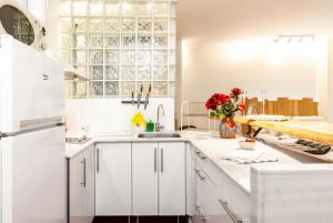 a white kitchen with white cabinets and a sink at Reino de Asturias, WIFI, VUT155 in Oviedo