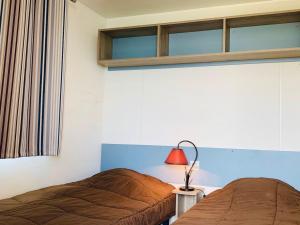 ein Schlafzimmer mit 2 Betten und einer roten Lampe in der Unterkunft Gîte Bures, 3 pièces, 4 personnes - FR-1-584-305 in Bures