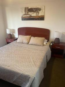 a bedroom with a bed with two nightstands and two lamps at Casa Condominio en Tongoy cercano a puerto Velero in Tongoy