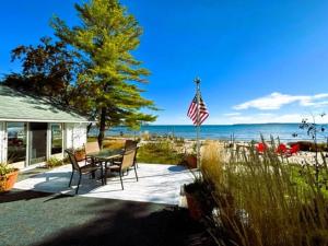 a patio with a table and chairs and a flag at The Huron Hutch in Evergreen Shores