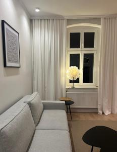 Una sala de estar con un sofá y una ventana. en Carola7, en Szczawno-Zdrój