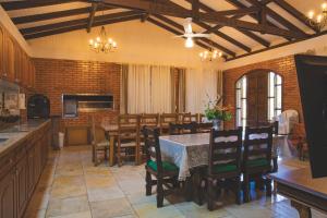 una cucina e una sala da pranzo con tavolo e sedie di Sítio Vale dos Vinhedos a Bento Gonçalves