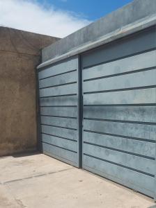 a pair of metal garage doors on a building at Esquina Apart in Alta Gracia